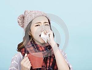 Sick young woman blowing her nose