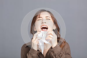 Sick young woman  blowing her nose