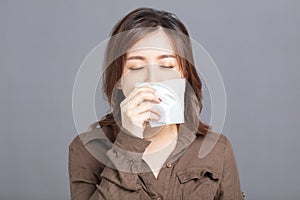 Sick young woman  blowing her nose