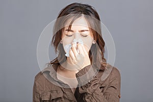 Sick young woman  blowing her nose