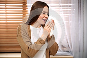 Sick young woman sneezing. Influenza virus