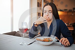 Sick young woman start to vomit. She cover mouth with hand and keep eyes closed. Model feels bad. She has glass of red