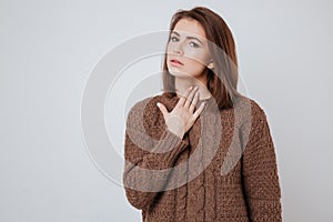 Sick young woman touching her neck.