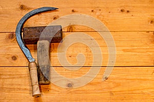 Sickle and hammer on a wooden table.