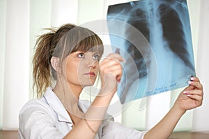 Sickness. Female doctor examining an x-ray photo