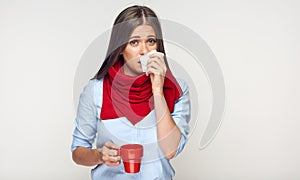 Sickness woman holding red cup blow up nose in paper tissue.