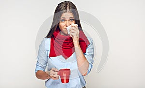 Sickness woman holding red cup blow up nose in paper tissue.