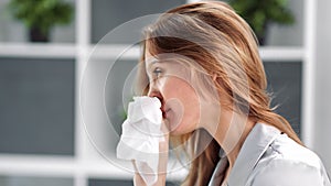 Sickness young blonde lady with viral infection sneezing. Shot with RED camera in 4K