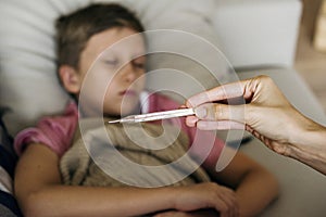 A sickness young boy with thermometer photo