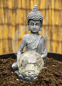 Siddharrtha Guautama with crystal ball on a cane fence.