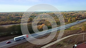 Side aerial view of red truck with cargo trailer driving on the highway.