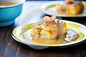 side angle of biscuit halves smothered in thick, peppery gravy