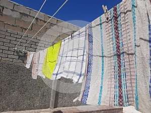 side angle dish cloths hanging on the washing line on a sunny day, time to clean up day