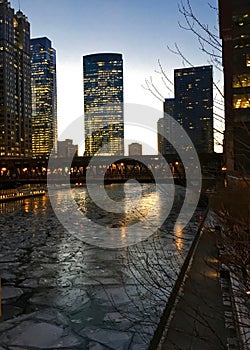 Side angle view of Chicago city night lights illuminated and reflected onto a frozen Chicago River.