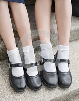 Side of Asian Thai girls schoolgirl student legs and feet with black shoes photo