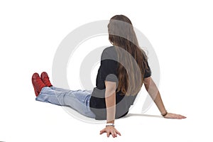 side and back view of a young girl sitting on the floor with Stretched legs