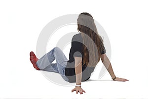 side and back view of a young girl sitting on the floor on white