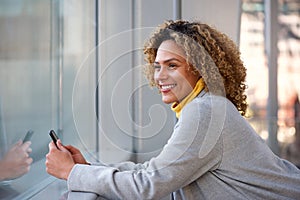 Side of beautiful african american woman smiling with mobile phone