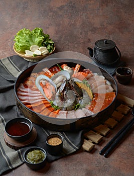 Side of beef garnished with sesame, and shellfish with prawns arranged on the tray combined with vegetables for grill set on the