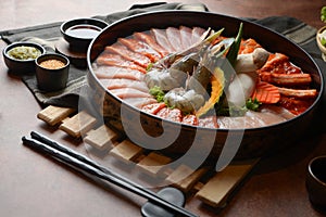 Side of beef garnished with sesame, and shellfish with prawns arranged on the tray combined with vegetables for grill set on the