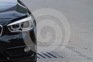 Side of black car with clear light headlight