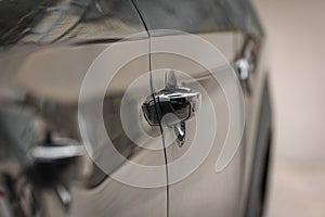 Side of the black car - perspective view. The door handle of a modern car
