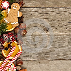 Side border of Christmas decor and treats over rustic wood photo