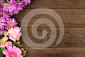 Side border of pink and purple flowers against a rustic wood background