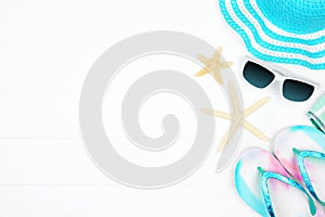 Side border of summer vacation beach accessories on a white wood background with copy space