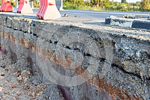 Side of the broken asphalt road collapsed and fallen. Road collapses. Layer of soil beneath section. Cracked asphalt road. constru