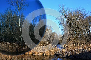 Side channel of Black Water Cierna Voda river in Galanta district, western Slovakia, viewed through photochromic lens with UV