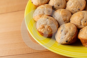 Side close view of baked chocolate chip muffins on a yellow plate