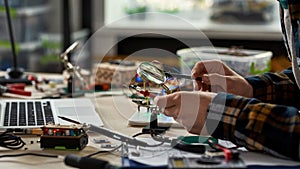 Side of cropped male engineer soldering microchip