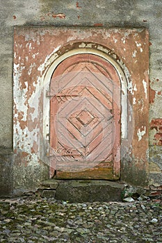 Side doors with large decorative hinges in an old small church