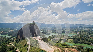 Side drone view overlooking the PeÃ±Ã³n of GuatapÃ© rock in Colombia