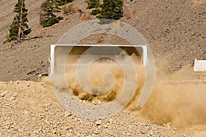 A side dumping trailer dumping its dusty load