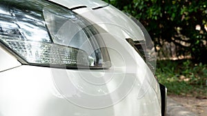 Side of front white car close up on car headlights.