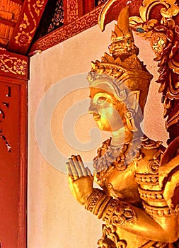Side of golden goddess sculpture of Thai Deva and greet action.