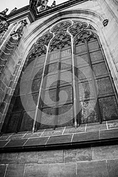 Side of the gothic Vysehrad cathedral in Prague featuring beautiful windows and stone wall and pillars