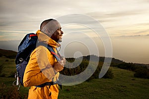 Side of happy male backpacker walking outdoors in nature