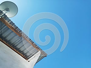 Side of A House Building with TV Antena and Clear Blue Sky Backgroung