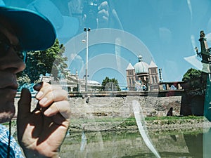 Side iew of pensive senior passenger tourist sightseeing through the large glass photo