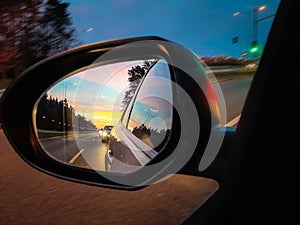 Side mirror of the car with amazing sunset