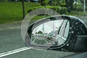 A side mirror of a car in rainy weather and traffic jams.in focus raindrops of the car.