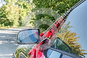 Side mirror of a car after a violent accident with police barrier tape in red and white with the German word for police barricade,