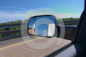 Side mirror showing travel trailer being pulled
