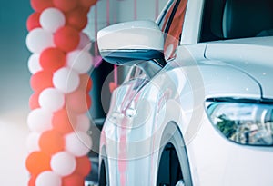 Side mirror white car parked in modern showroom. New and luxury compact car. Car dealership concept. Automotive industry.