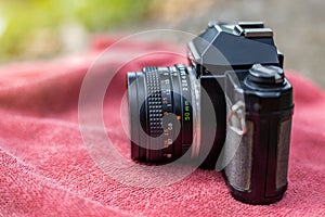 The side of an old black film camera with a red towel