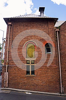 Side of an old brick building with a high loading door.