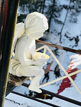 Side photo of fairy child statue in snow region of Himalaya